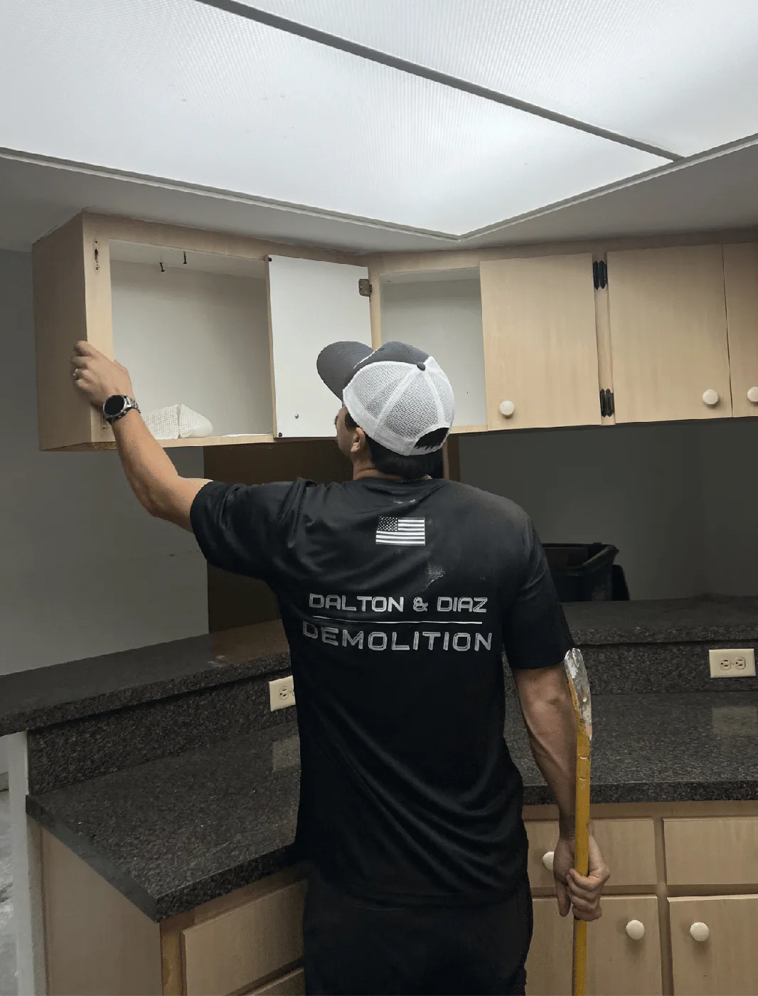 DND Demolition crew removing kitchen cabinets during a residential interior tearout